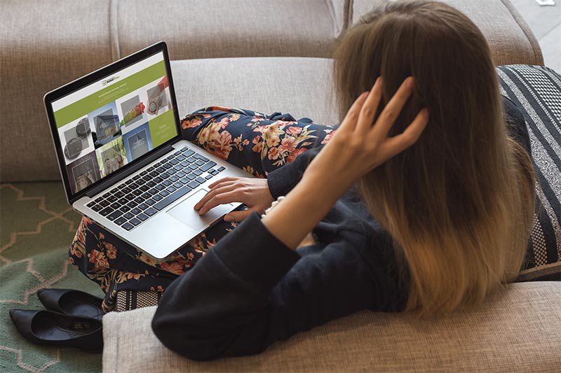 Frau auf Sofa mit Macbook