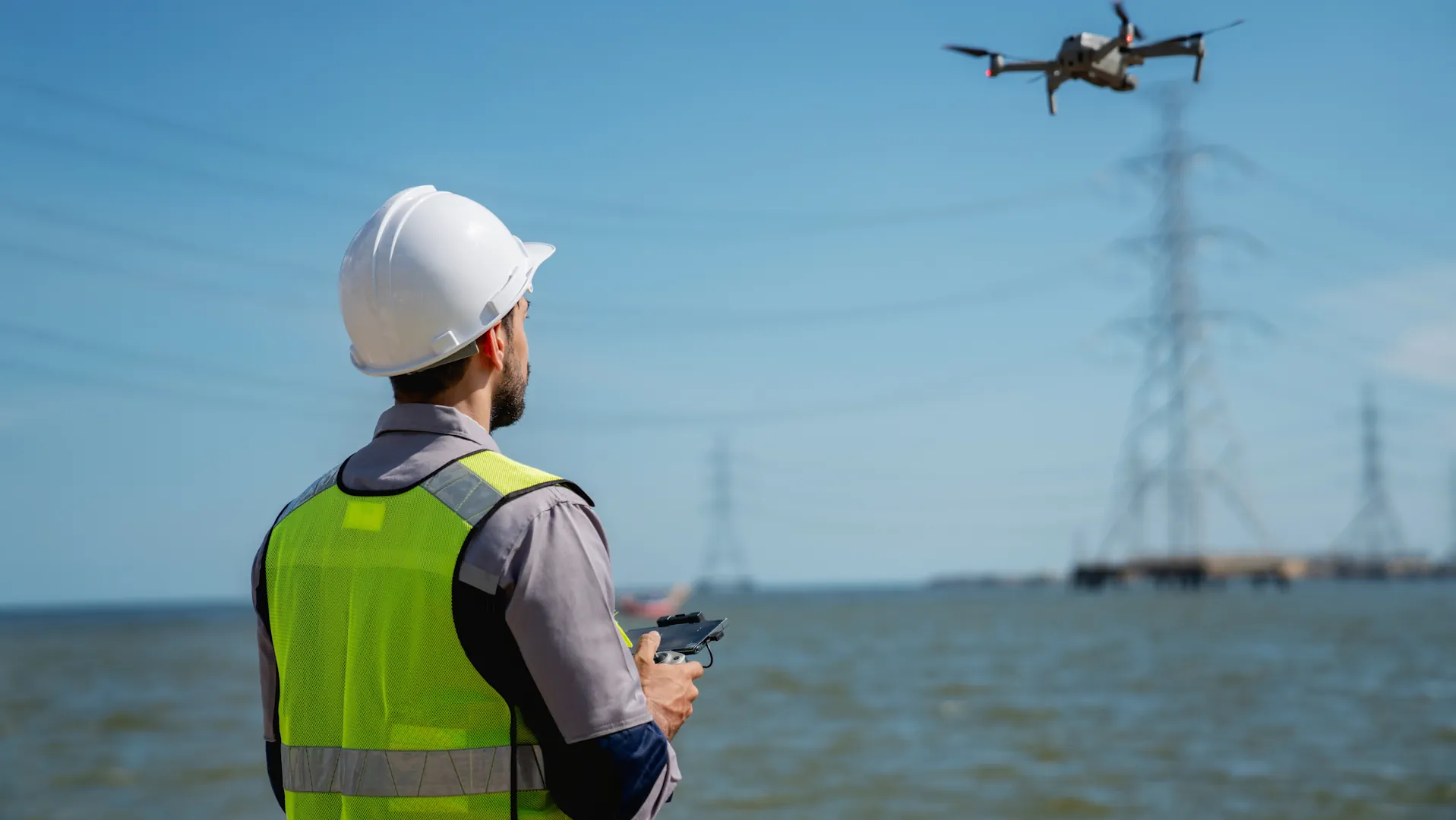 Techniker überwacht Energieanlage mit Drohne