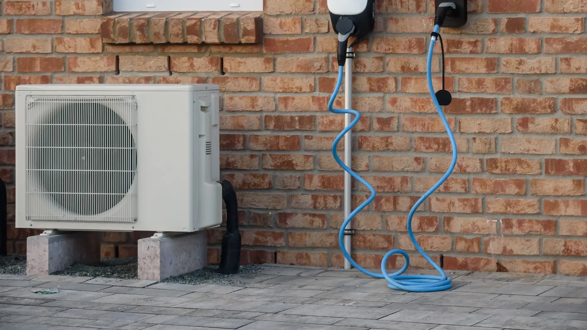 Nachhaltiges Wohnen: E-Ladegerät und Wärmepumpe. Modernes Zuhause mit energieeffizienten Lösungen, darunter eine Wärmepumpe und eine Ladestation für Elektrofahrzeuge (EV).