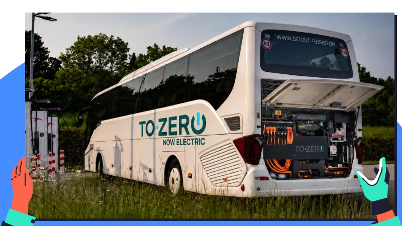 Ein umgerüsteter Elektro-Reisebus mit geöffneter Heckklappe zeigt orangefarbene Hochvolt-Kabel und elektrische Komponenten.