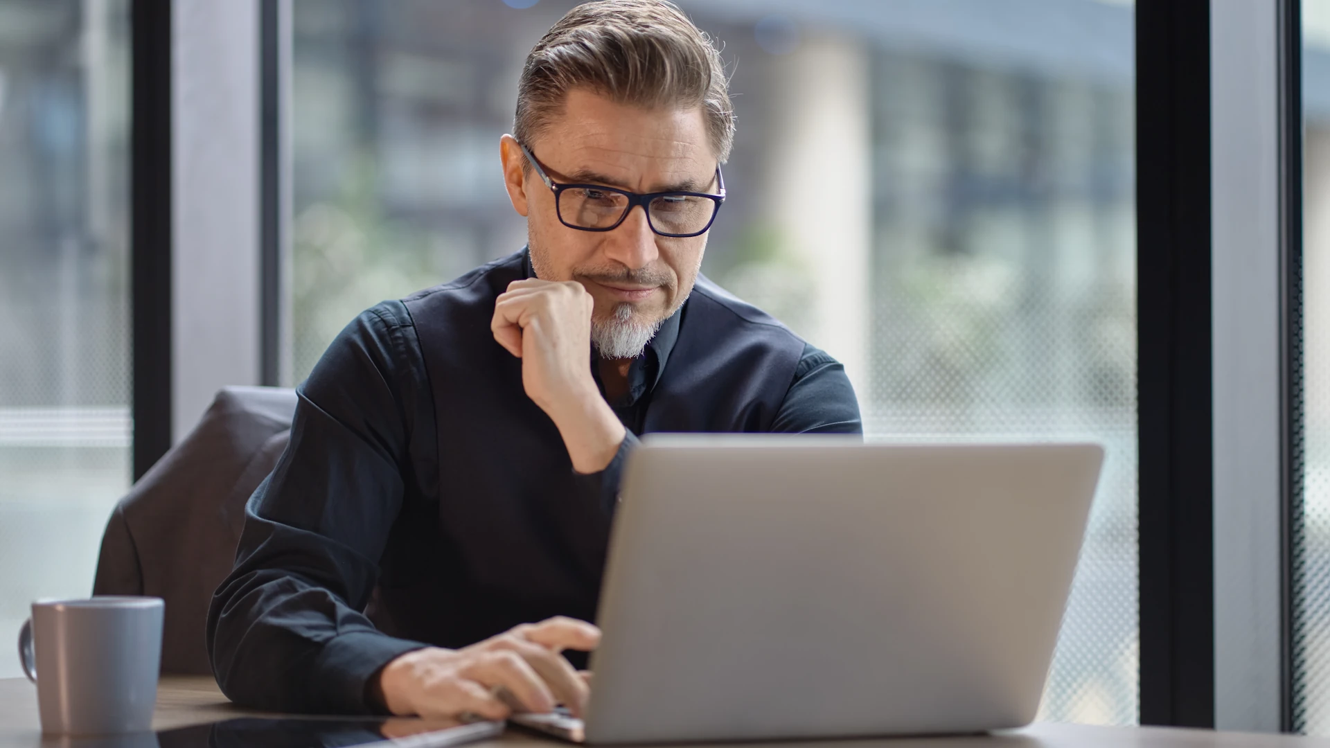 Mann sitzt am Laptop