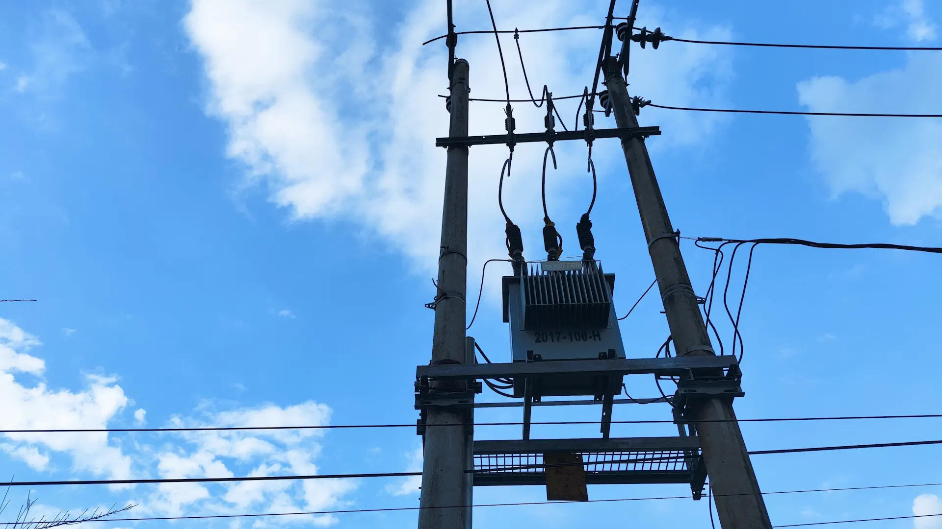 Strommast mit Transformator bei Tageslicht